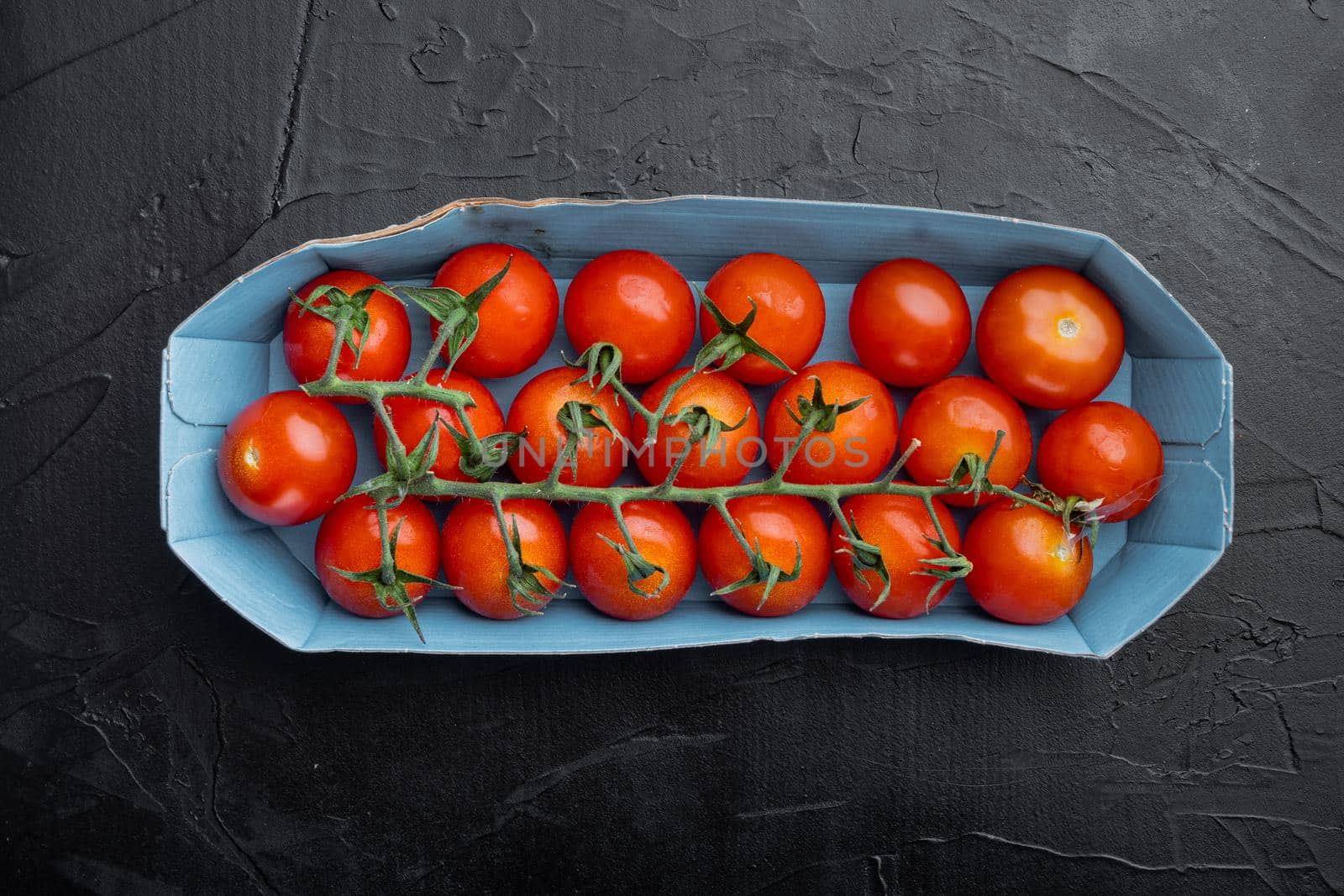 Fresh red organic cherry tomatoes, on black background