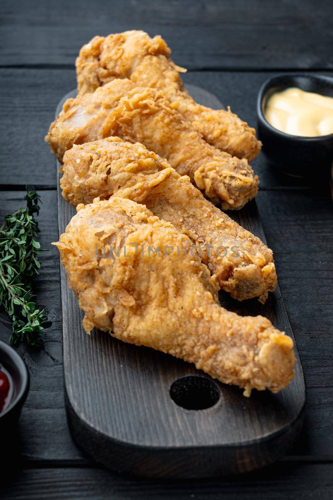 Crispy fried chicken cuts on black wooden table.