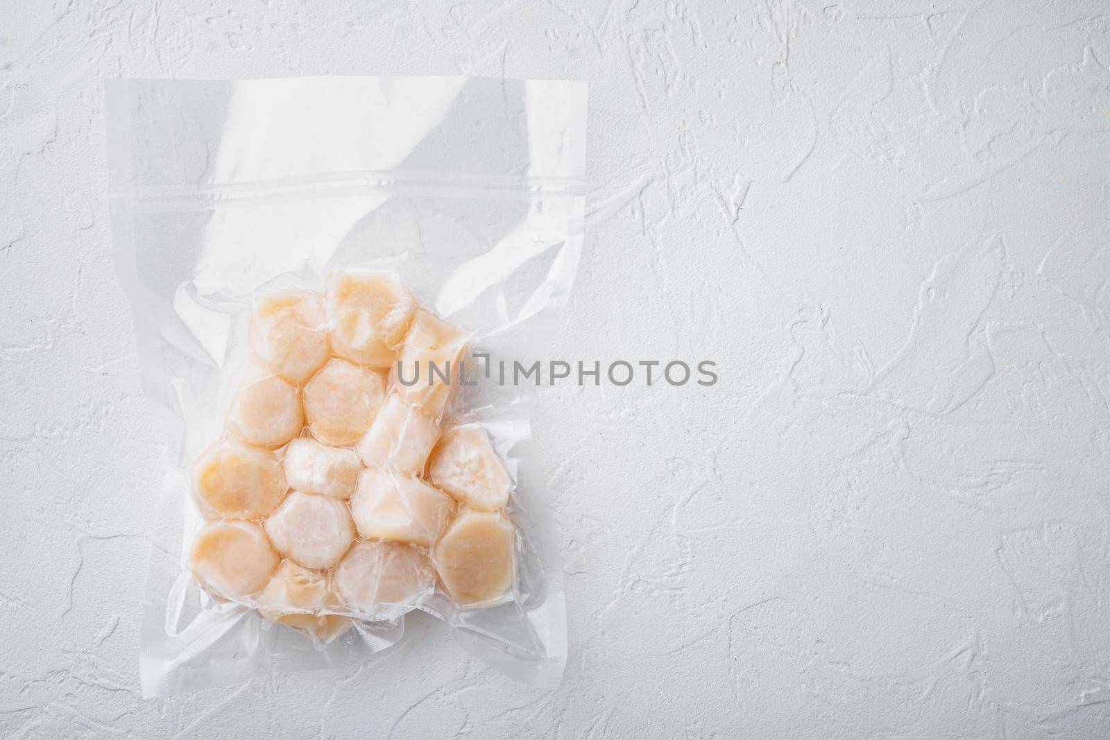 Frozen meat scallops in vacuum package, flat lay, on white textured background with space for text