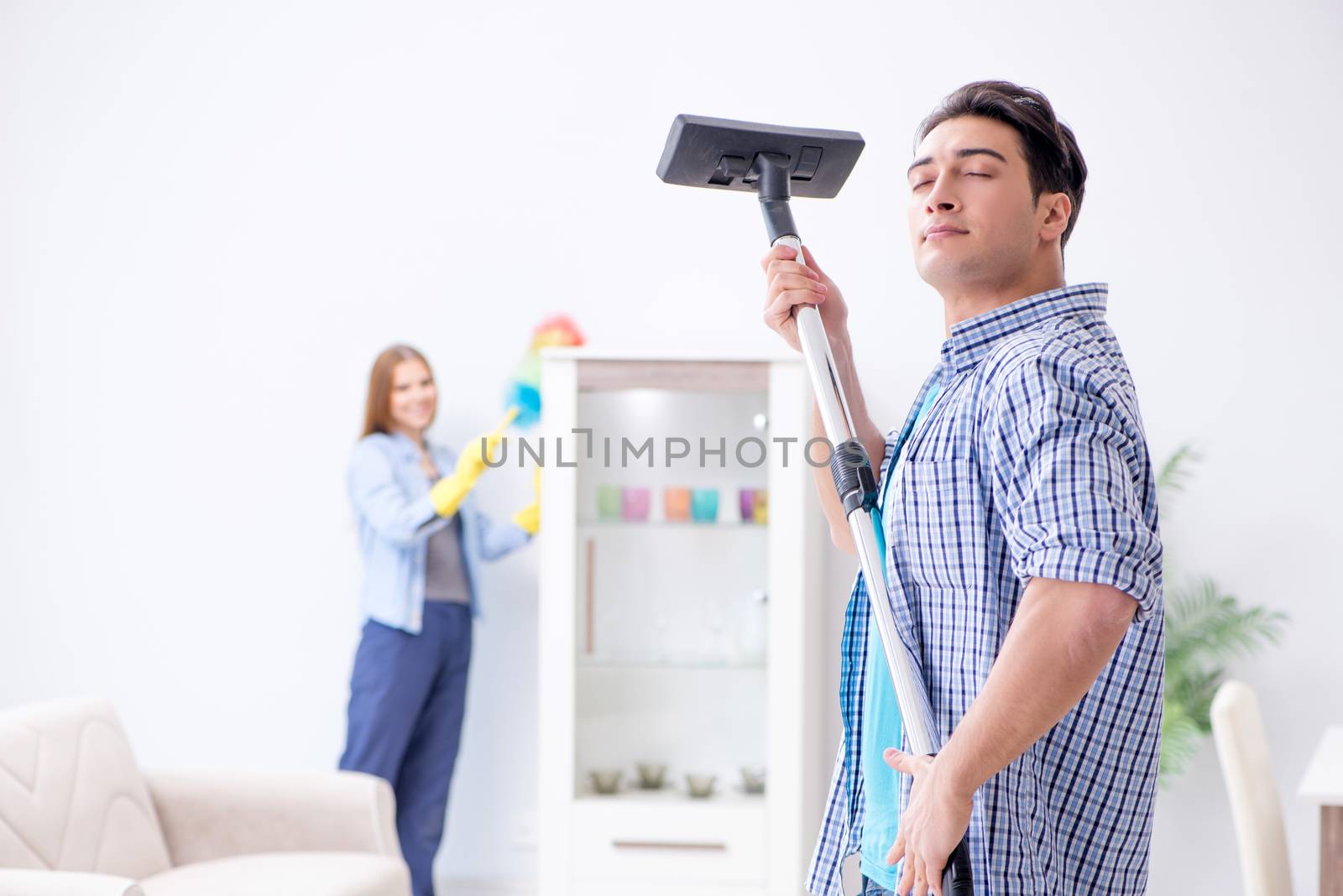 Young family cleaning the house by Elnur