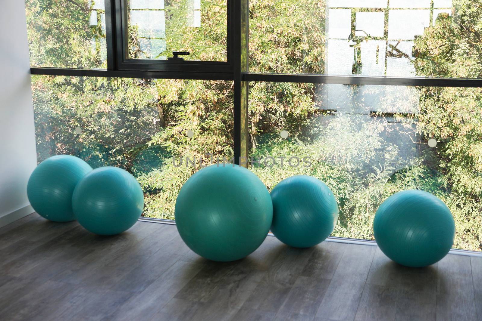 fitness balls by the window in the gym by Annado