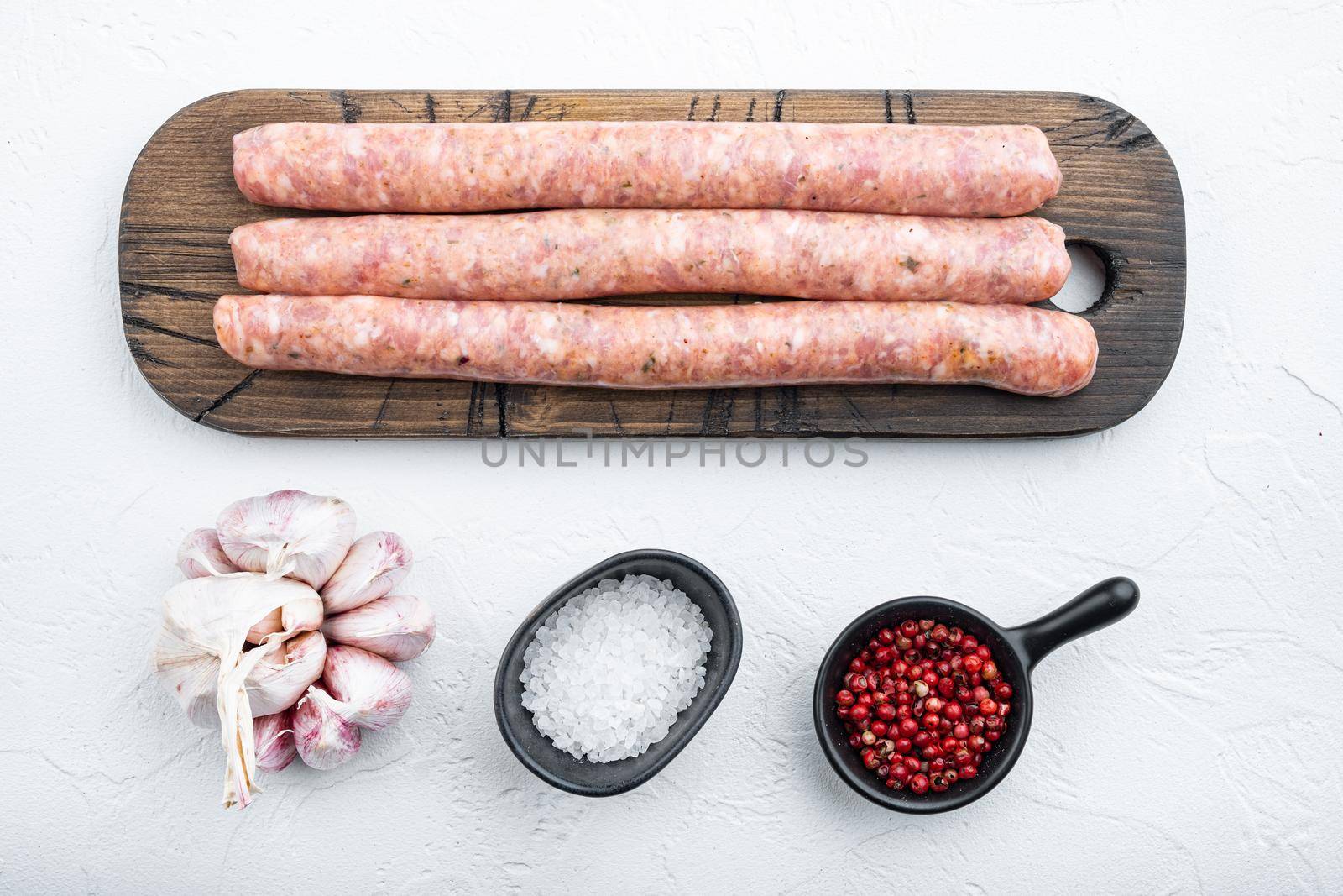 Homemade beef sausages, top view, on white background.