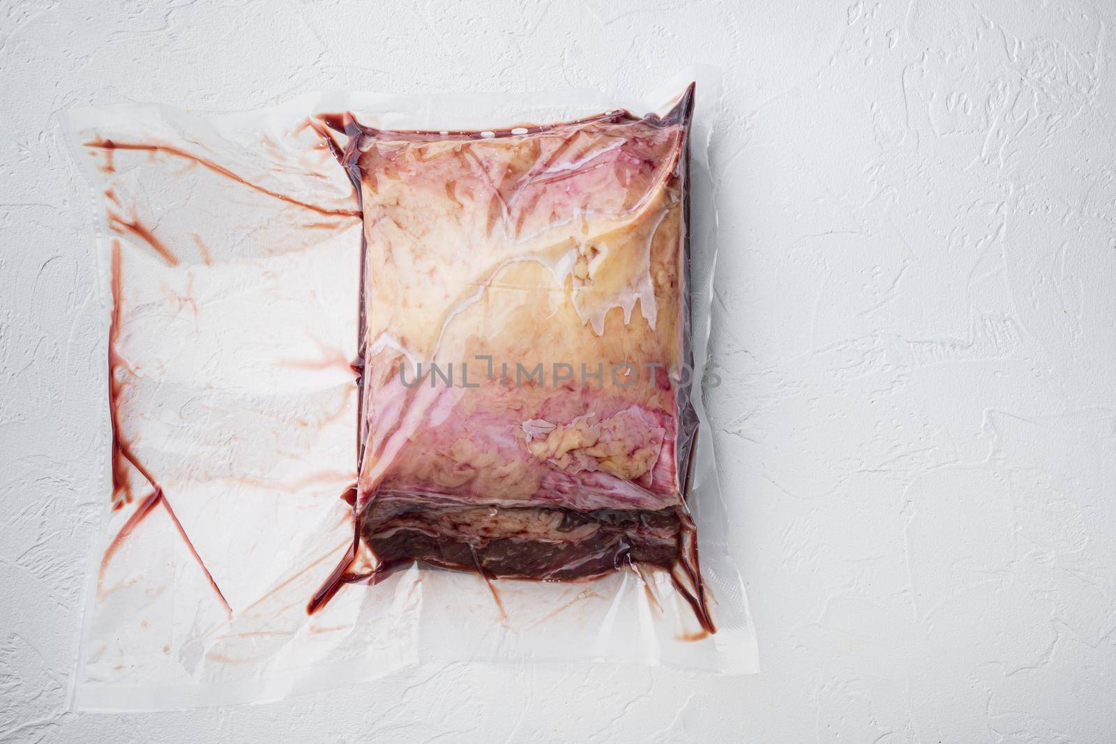 New York beef steak huge cut in plastic pack, on white background, top view, with copy space for text