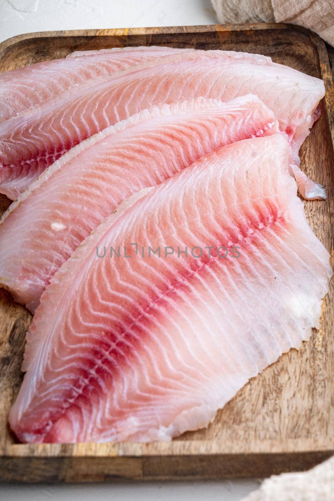 Tilapia fish fillet meat cuts, on white background