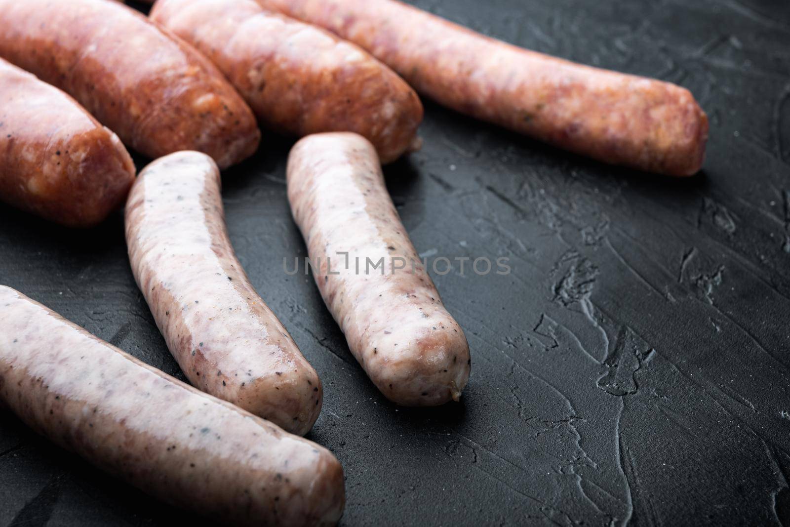 Raw homemade sausages, on black background.