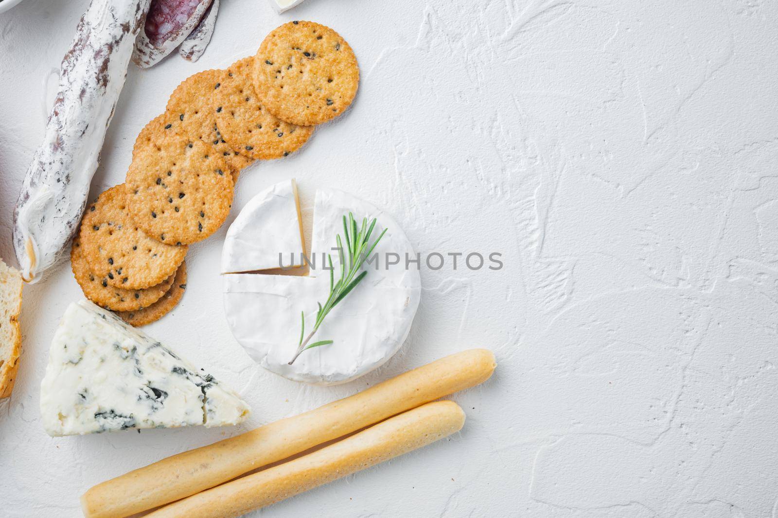 Antipasti platter with fresh cheese, bread and olive, on white background, flat lay with copy space for text