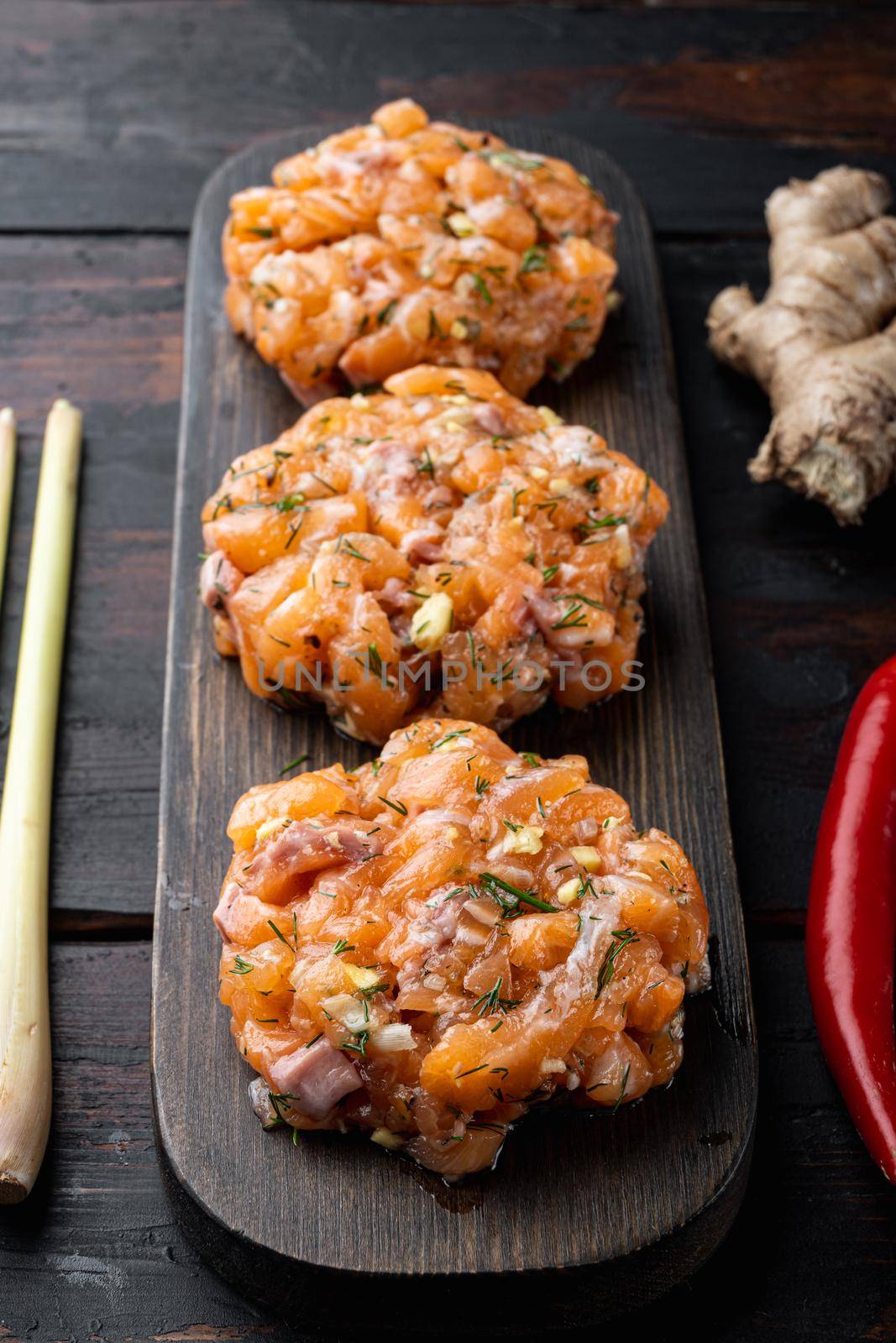 Raw fish patties with salmon fillet and lemongrass, on old wooden table
