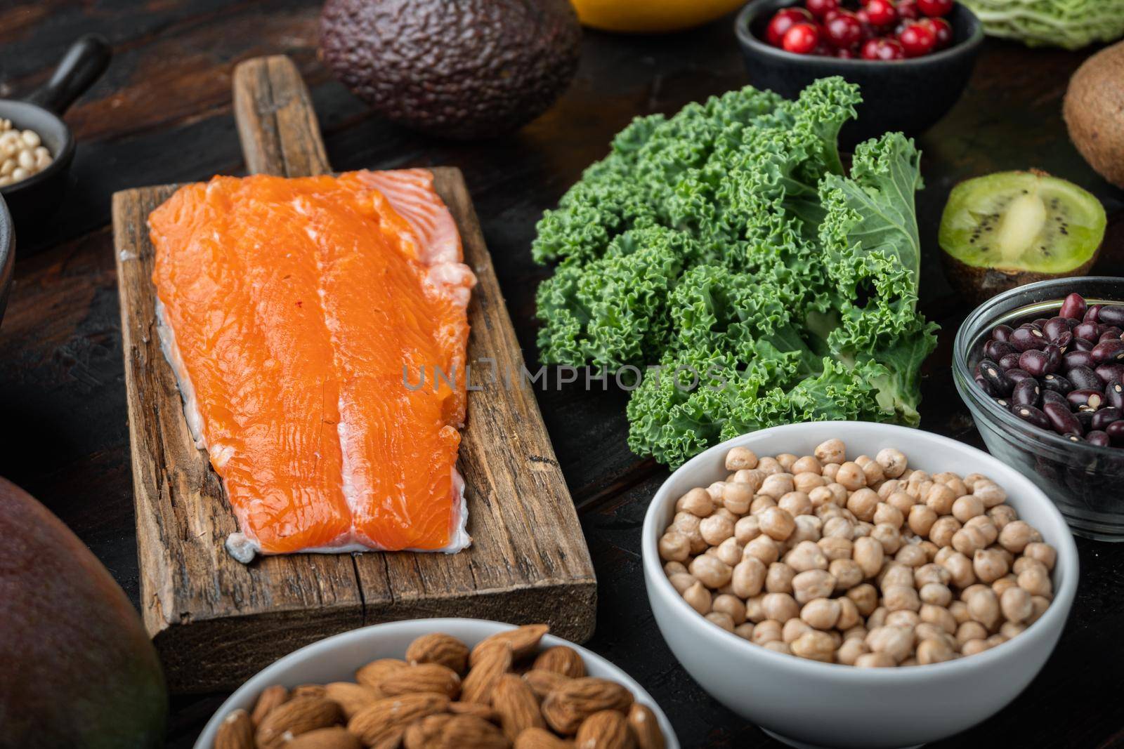 Healthy balanced dieting ingredients concept on dark wooden background.