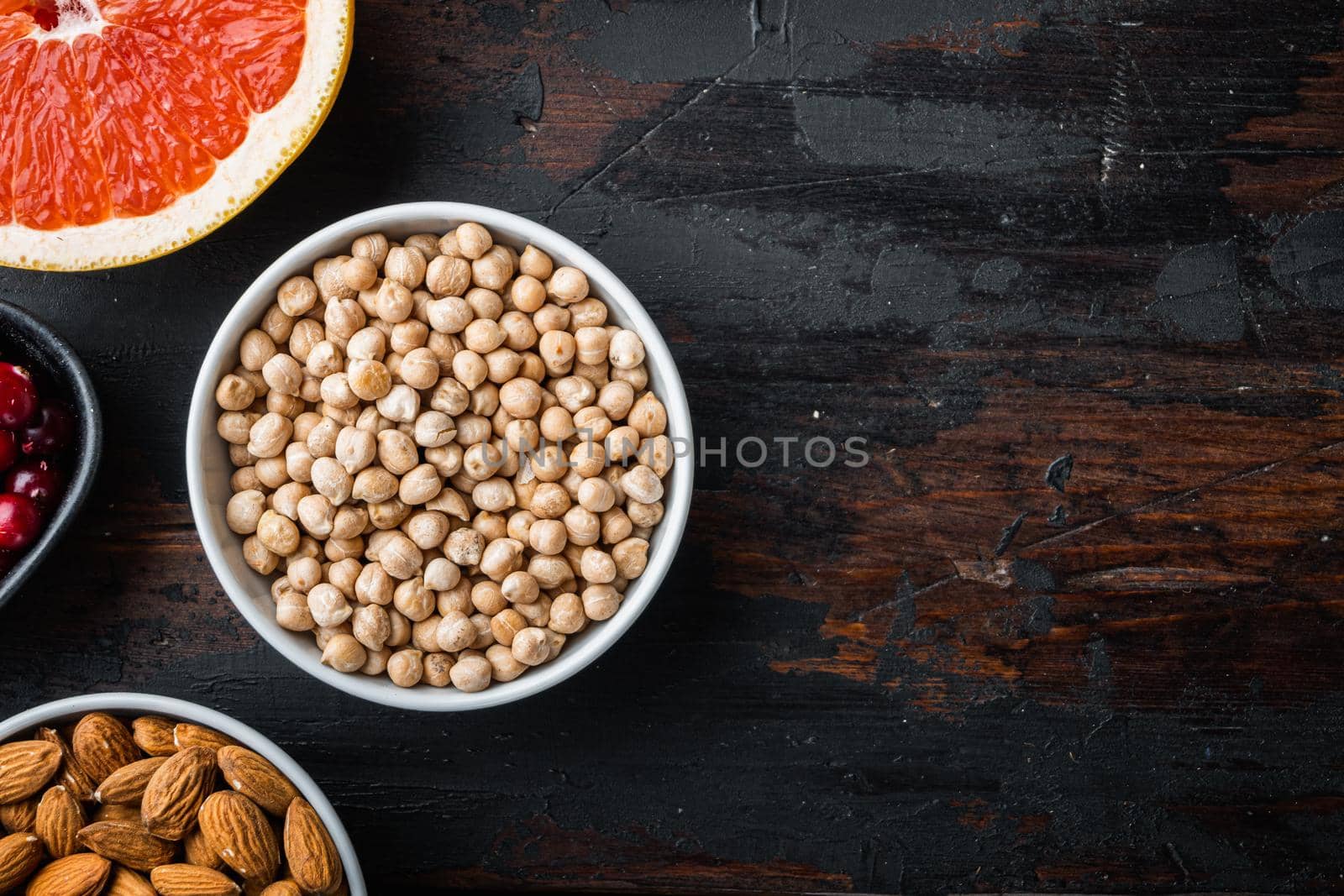 Chickpea in white bowl, top view on dark wooden background, with copy space.