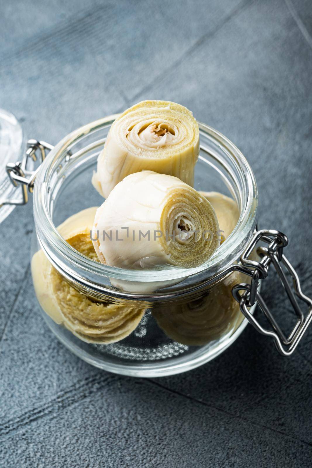 Canned artichokes with olive oil, on grey background