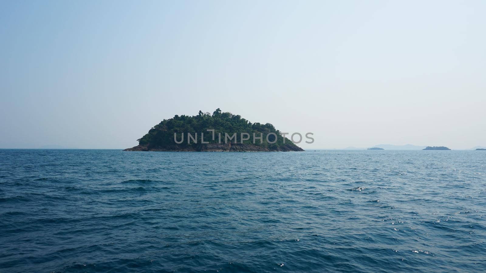 Travel by sea in Thailand by ship. View of the open ocean, green Islands and gray sky in smog. Green water with waves. Sailing between the Islands. Ship from different sides: stern, bow, rope, anchor.