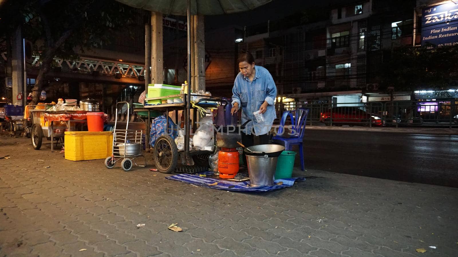 Walking street with food in Asia. Lots of variety. Asians prepare pancakes, kebabs, sate, corn, fish, juices, shakes. They sell different fruits. They smile and dance while cooking. Thai street food.