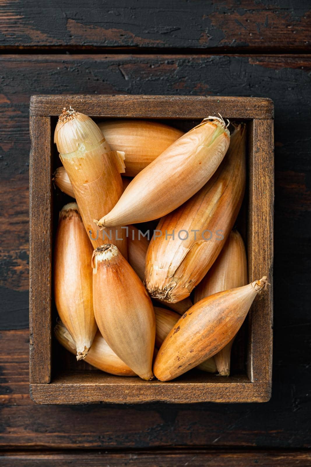 Raw whole baby shallot onion, on old wooden table, flat lay