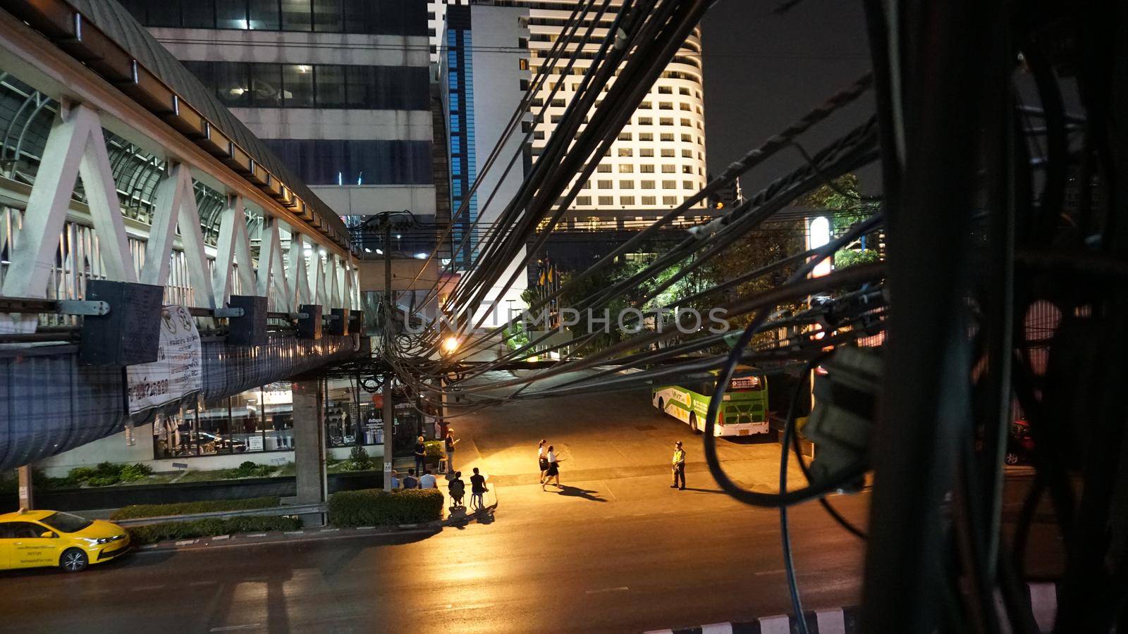 Bangkok night street. Overhead crossing and wires by Passcal