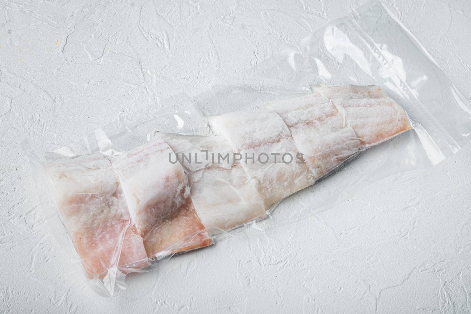 Raw haddock fish skinless plastic vacuum packaged, on white background