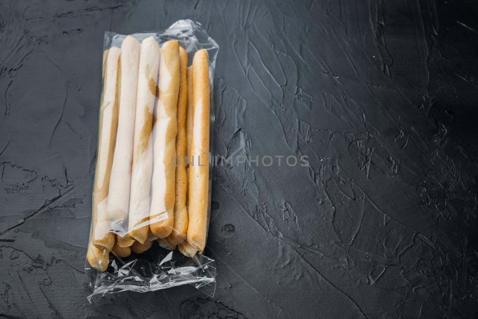 Grissini, with olive oil, on black background with copy space for text