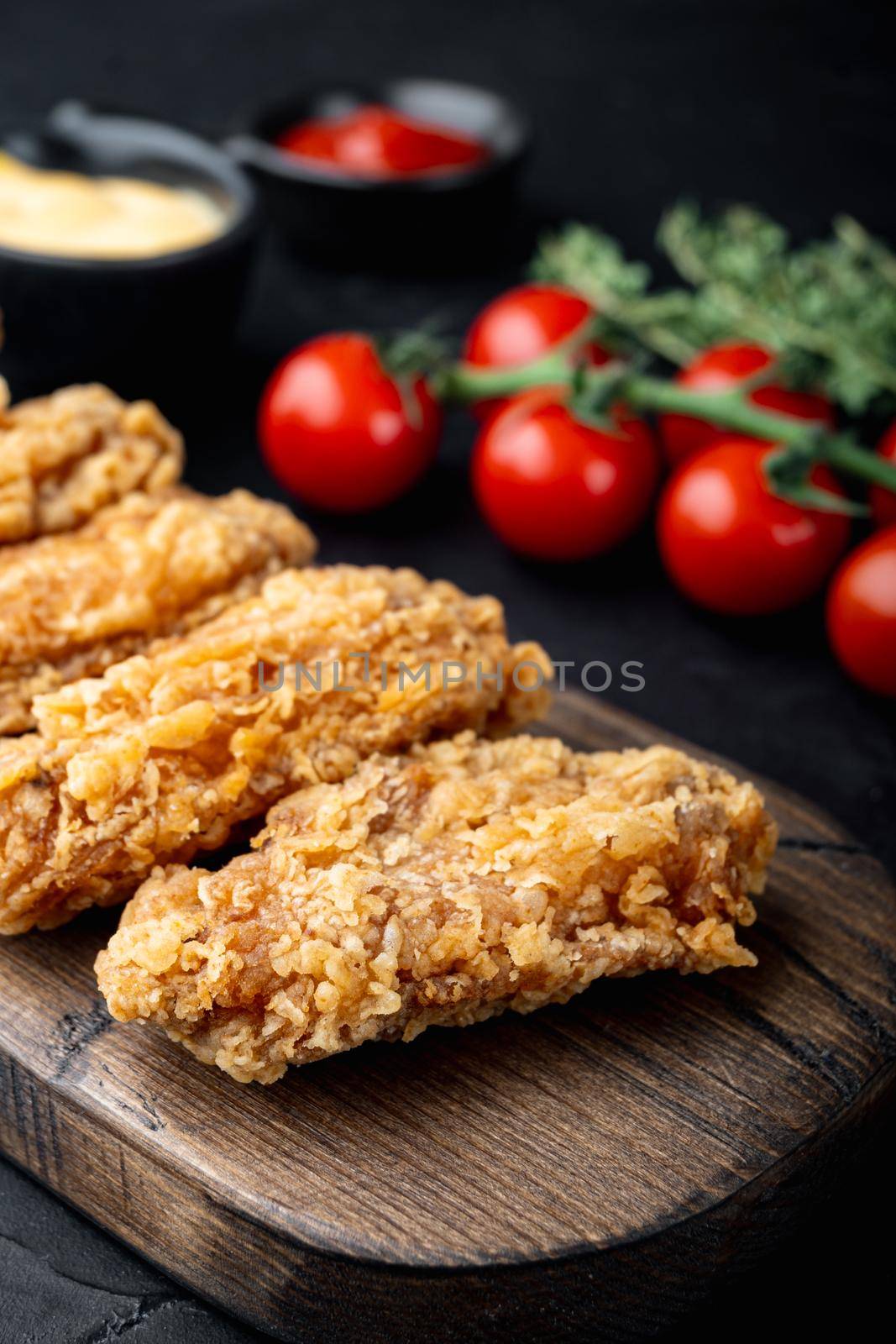 Fried chicken wings parts on black background.