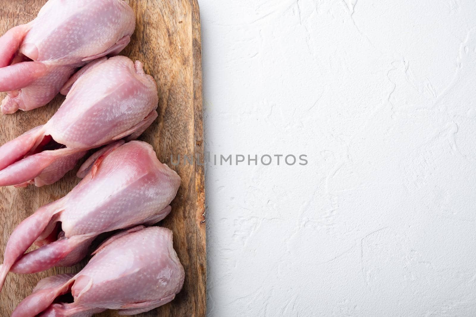 Fresh organic whole quail meat, flat lay, on white textured background with space for text