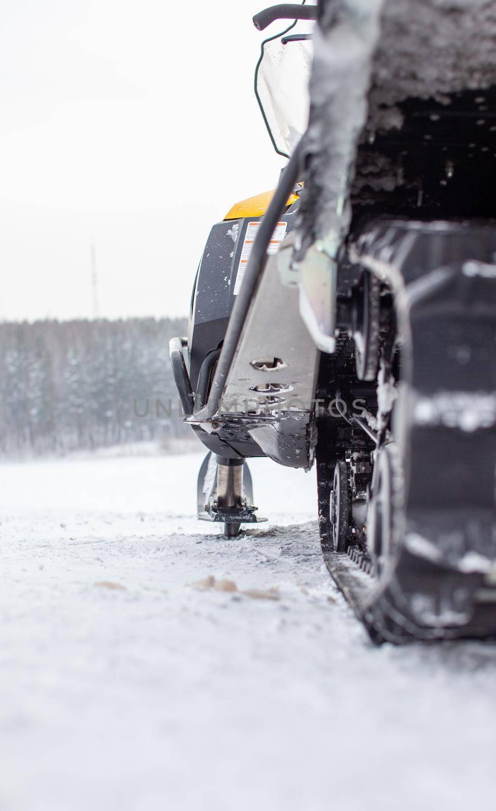 The back of the snowmobile in winter. Riding in the snow on a snowmobile. Rear suspension of a snowmobile