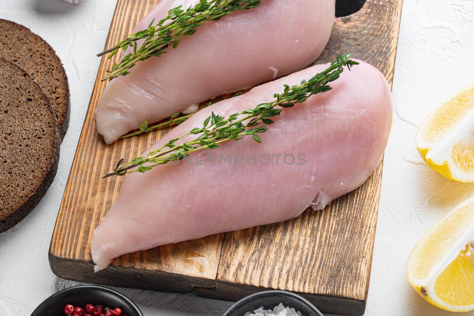 Crumbed uncooked chicken breasts ingredient on white background
