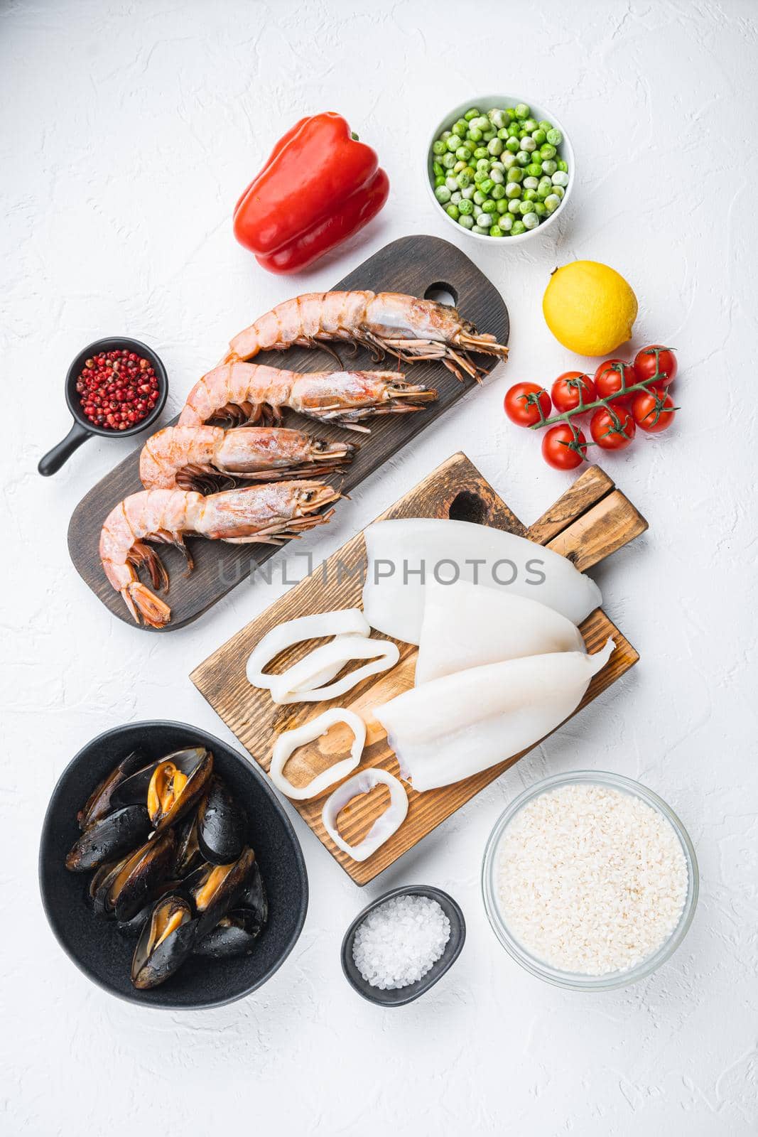 Seafood shrimps prawns squid mussels for paella on white background, top view, food photo.