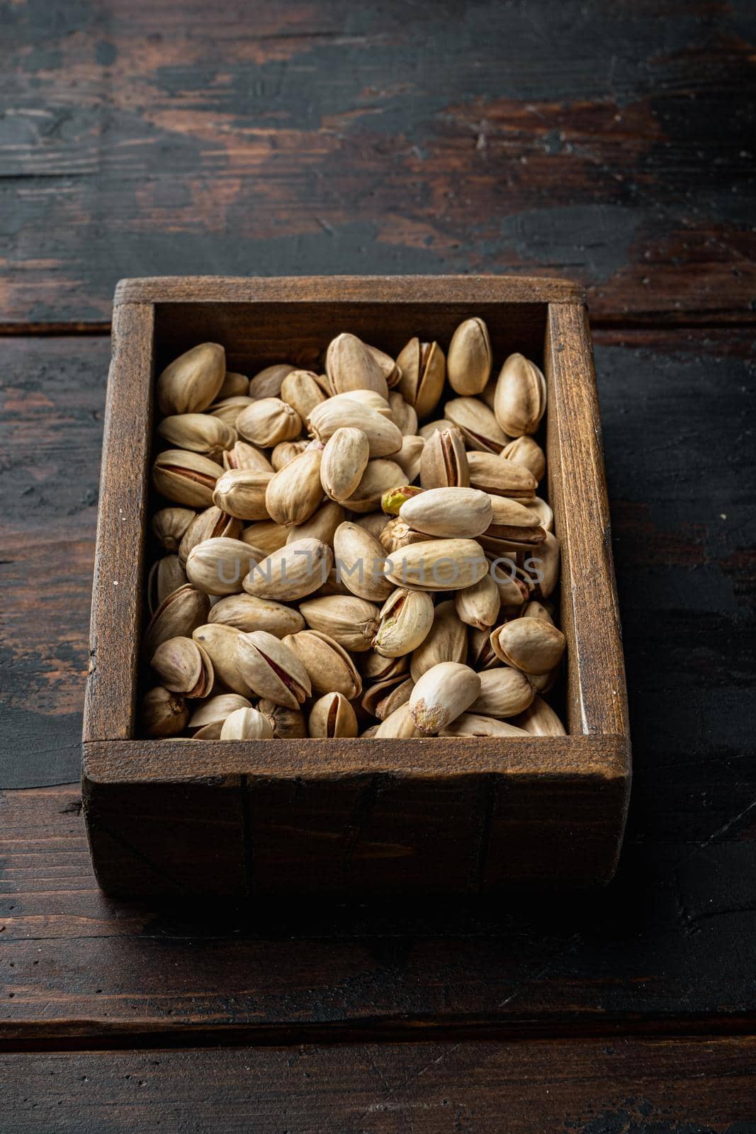 Shelled, unsalted pistachios, on old wooden table, top view