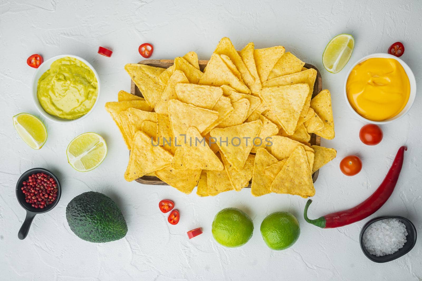 Homemade guacamole and cheese dip with nacho, on white background, top view or flat lay