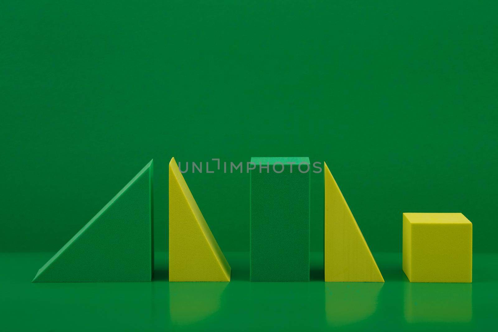 Green and yellow geometric figures against green background. Abstract monochromatic concept with space for text by Senorina_Irina