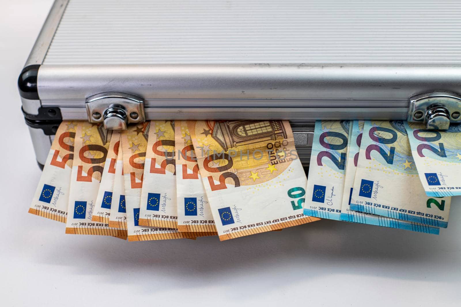 50 and 20 euro banknotes on aluminum briefcase on white background