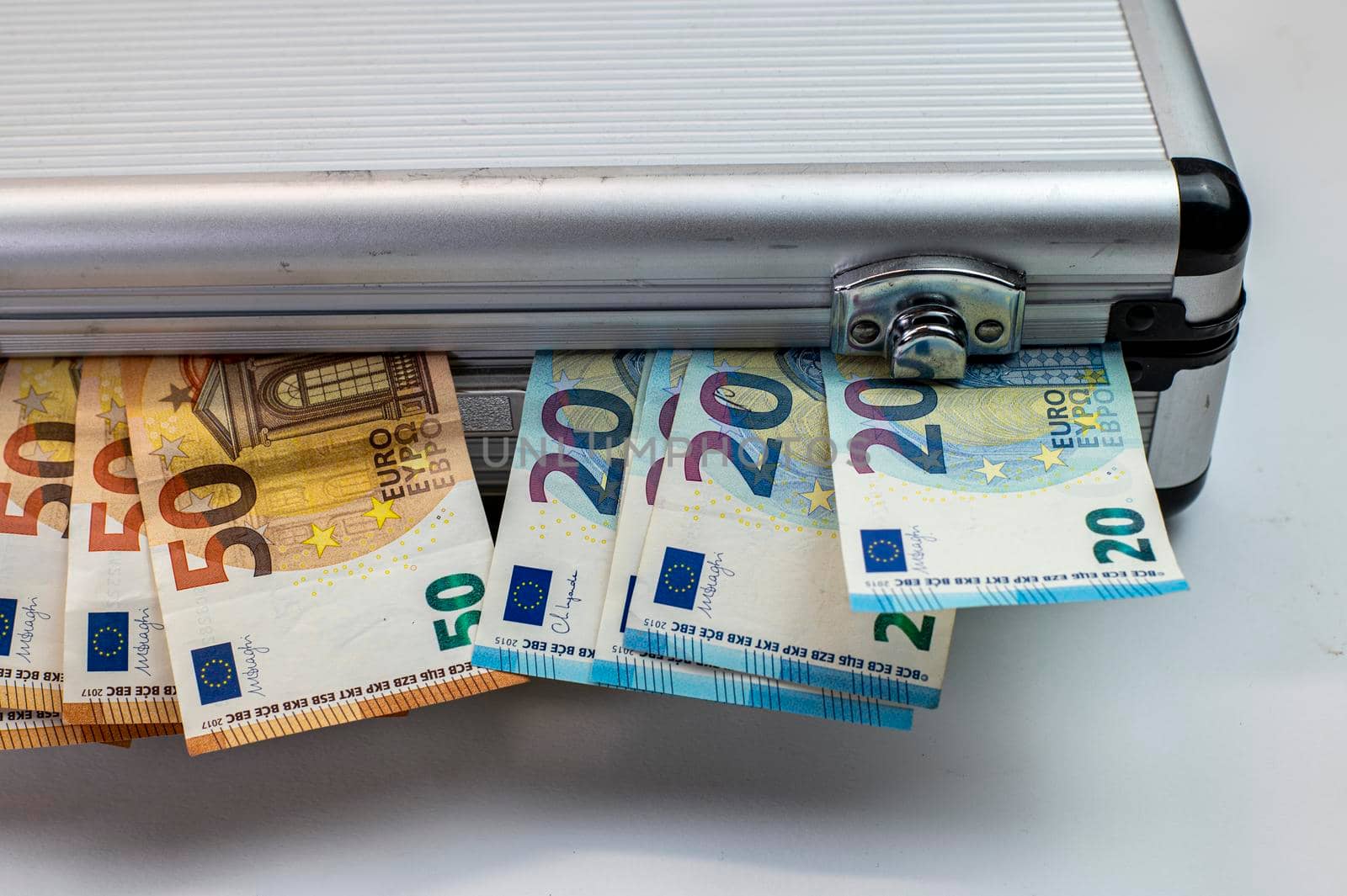 50 and 20 euro banknotes on aluminum briefcase on white background