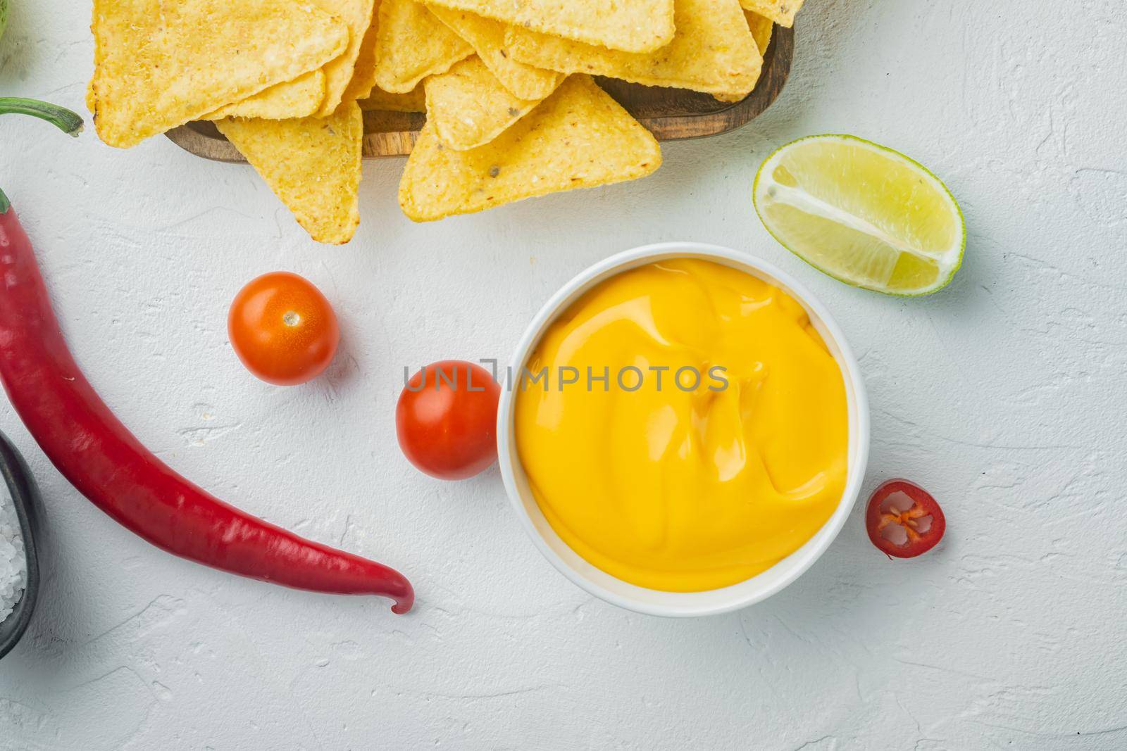 Bowl with cheese dip with nacho, on white background, top view or flat lay