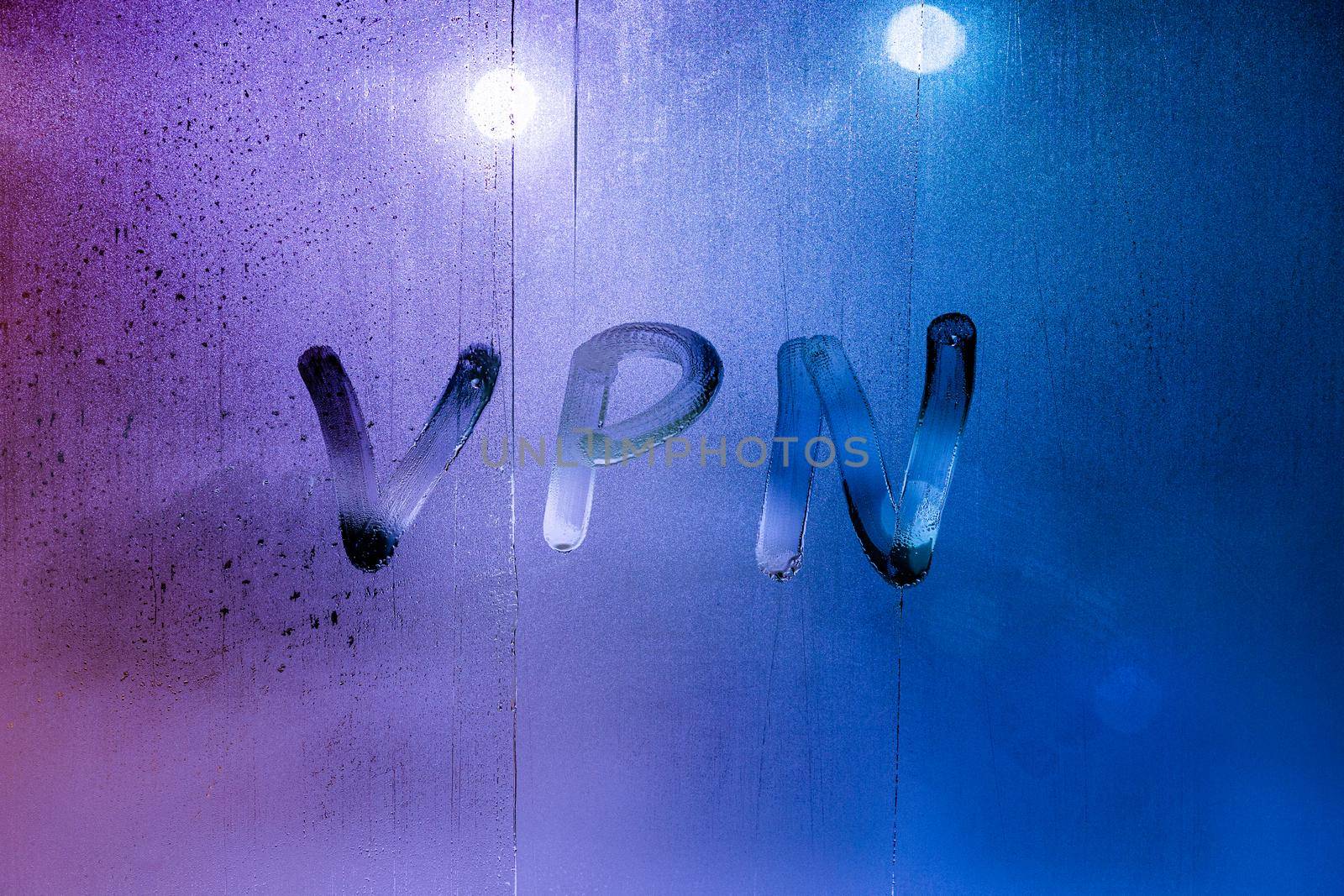 an abbreviation VPN - virtual private network drawed by finger on night wet glass.
