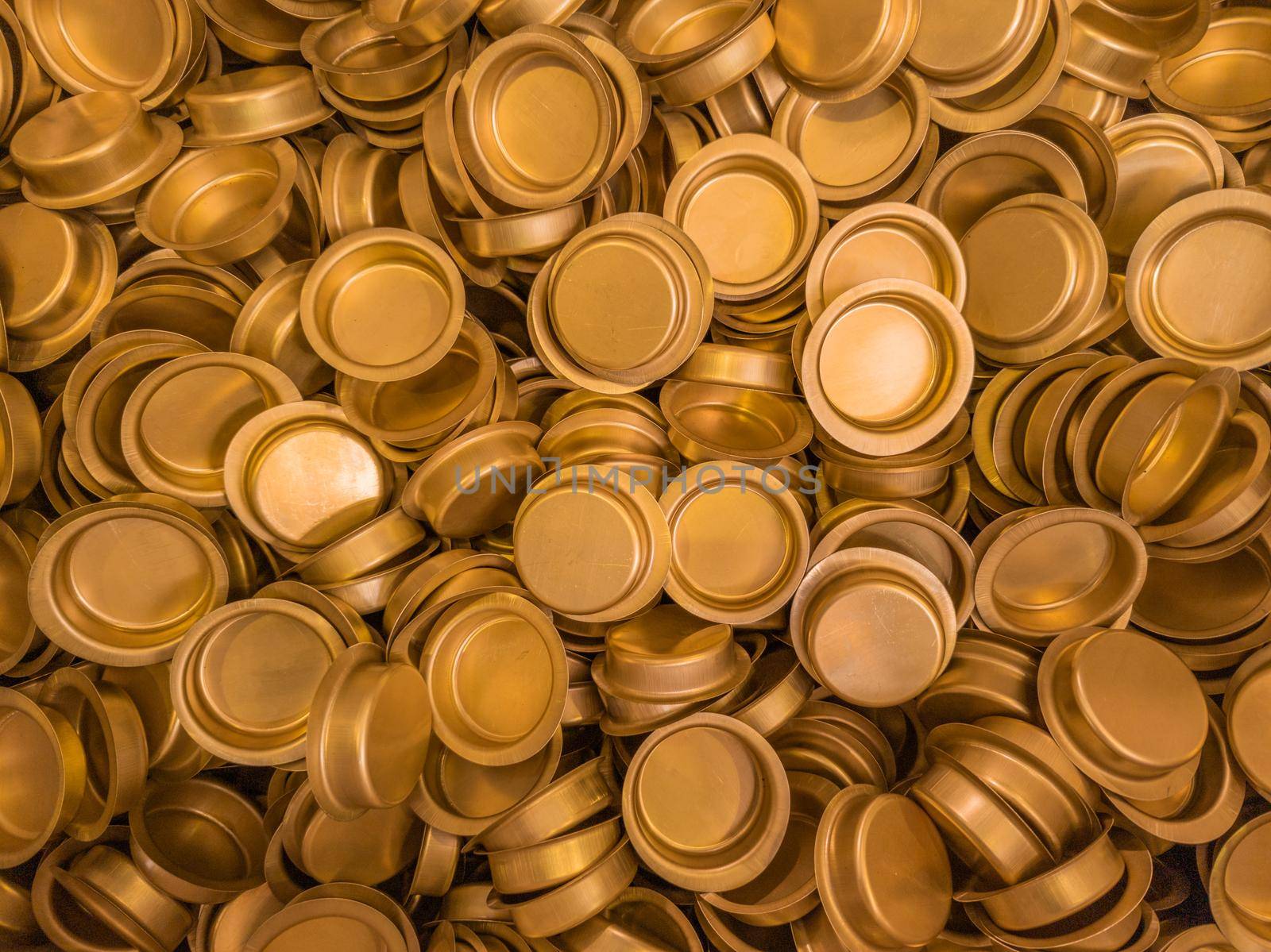pile of stamped thin sheet brass hat-shaped semimanufatures, full frame industrial manufacturing background