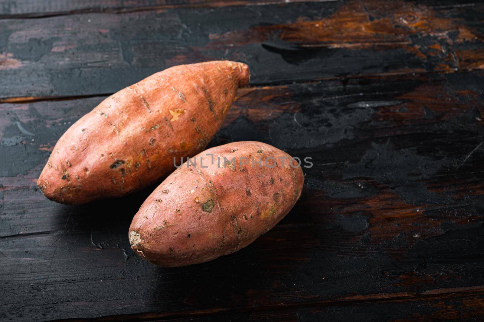 Sweet potato or batat on old wooden table with space for text.