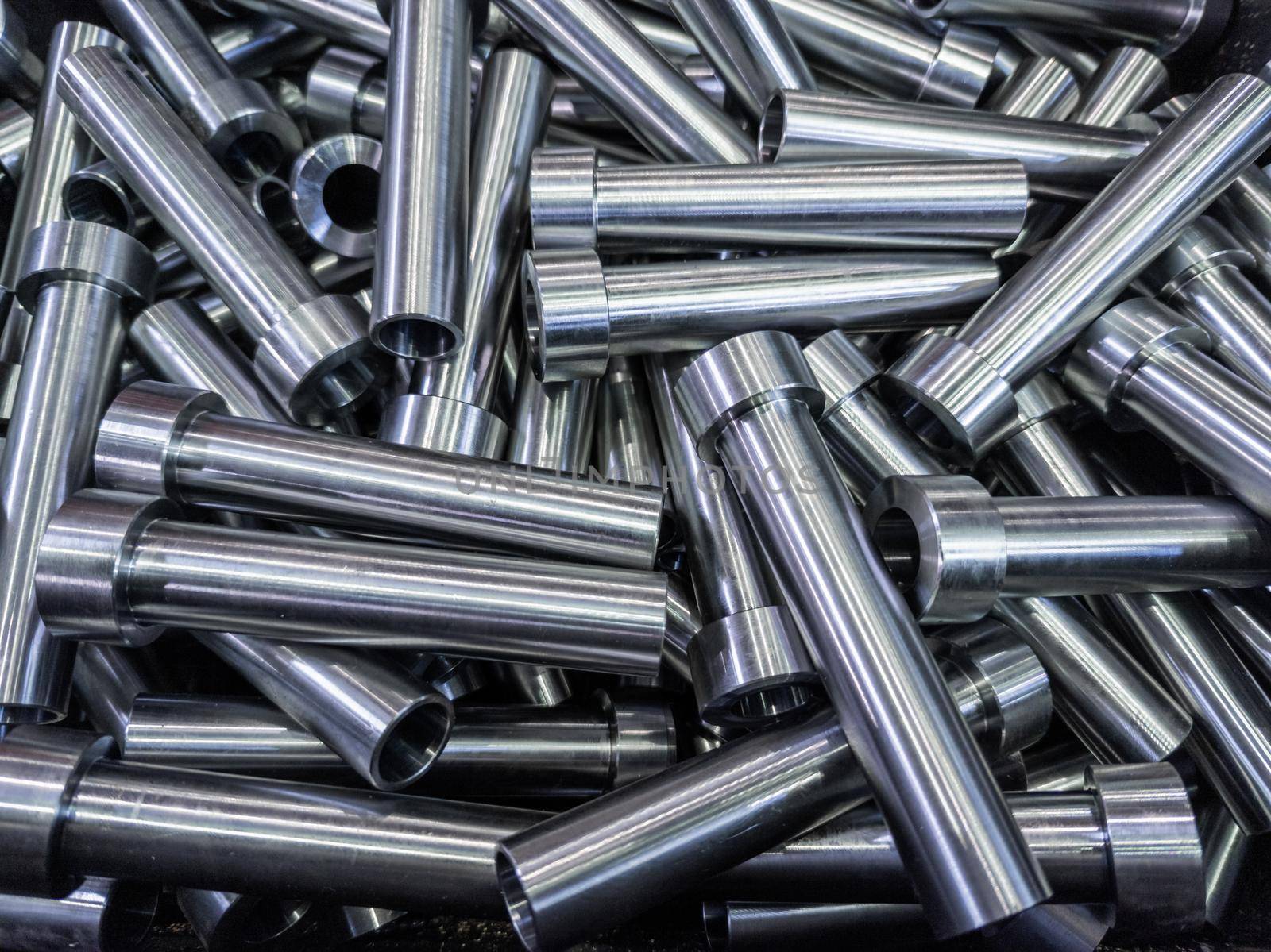 full frame abstract indistrial background of pile of shiny steel tubes after cnc turning operations