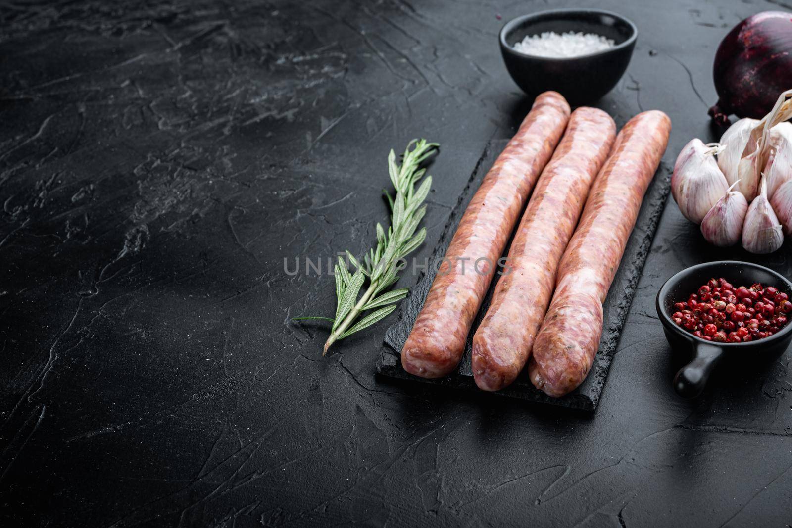 Beef sausages with space for text, on black background.