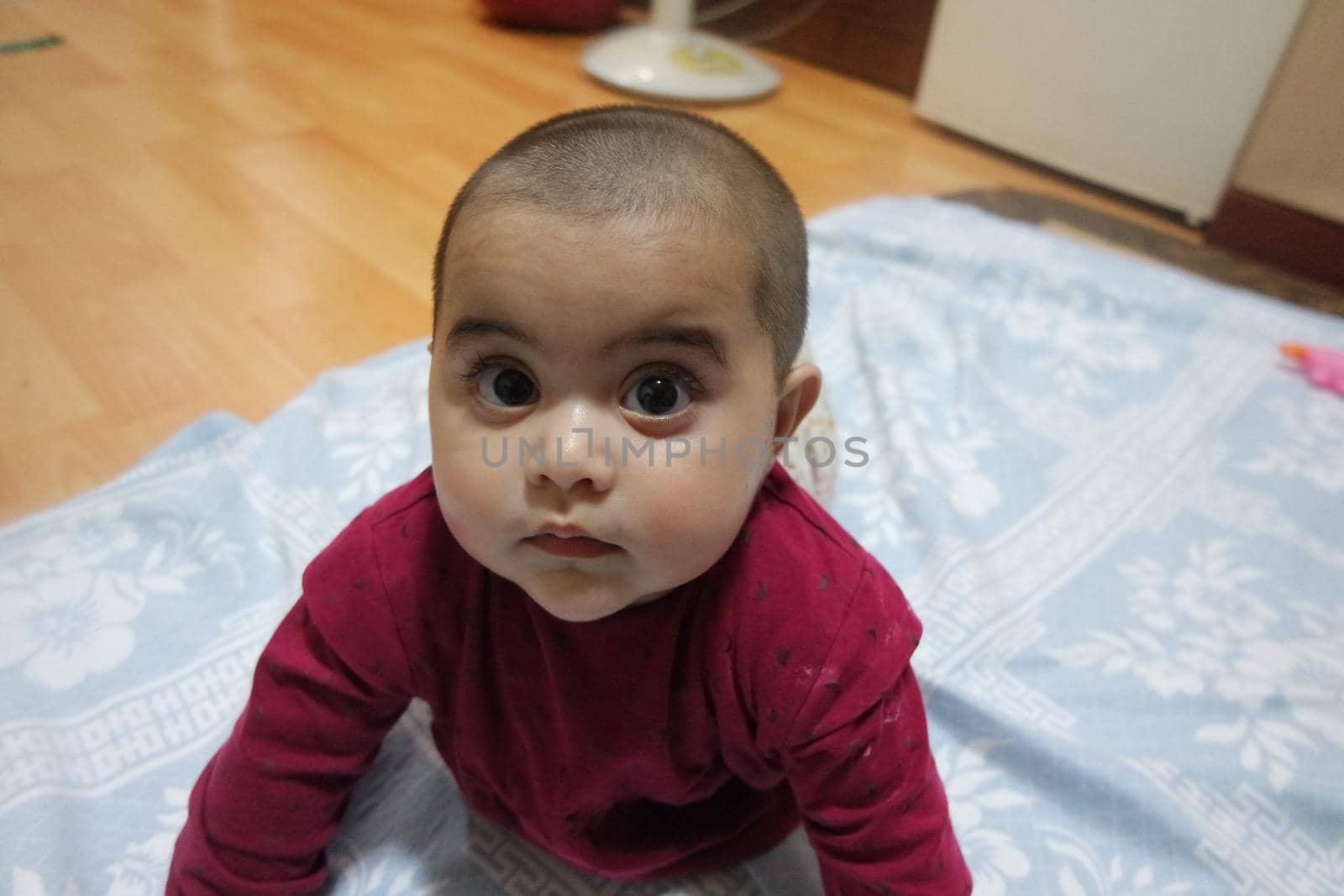 Baby girl with lovely face, big eyes and cute face gesture by Photochowk