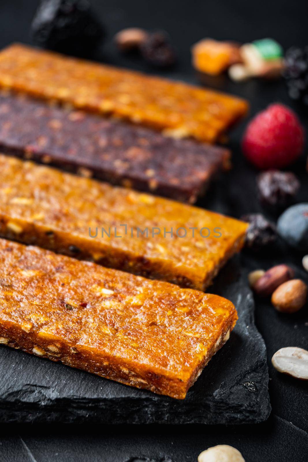 Fruit berry nut energy bars, healthy snack, on black background