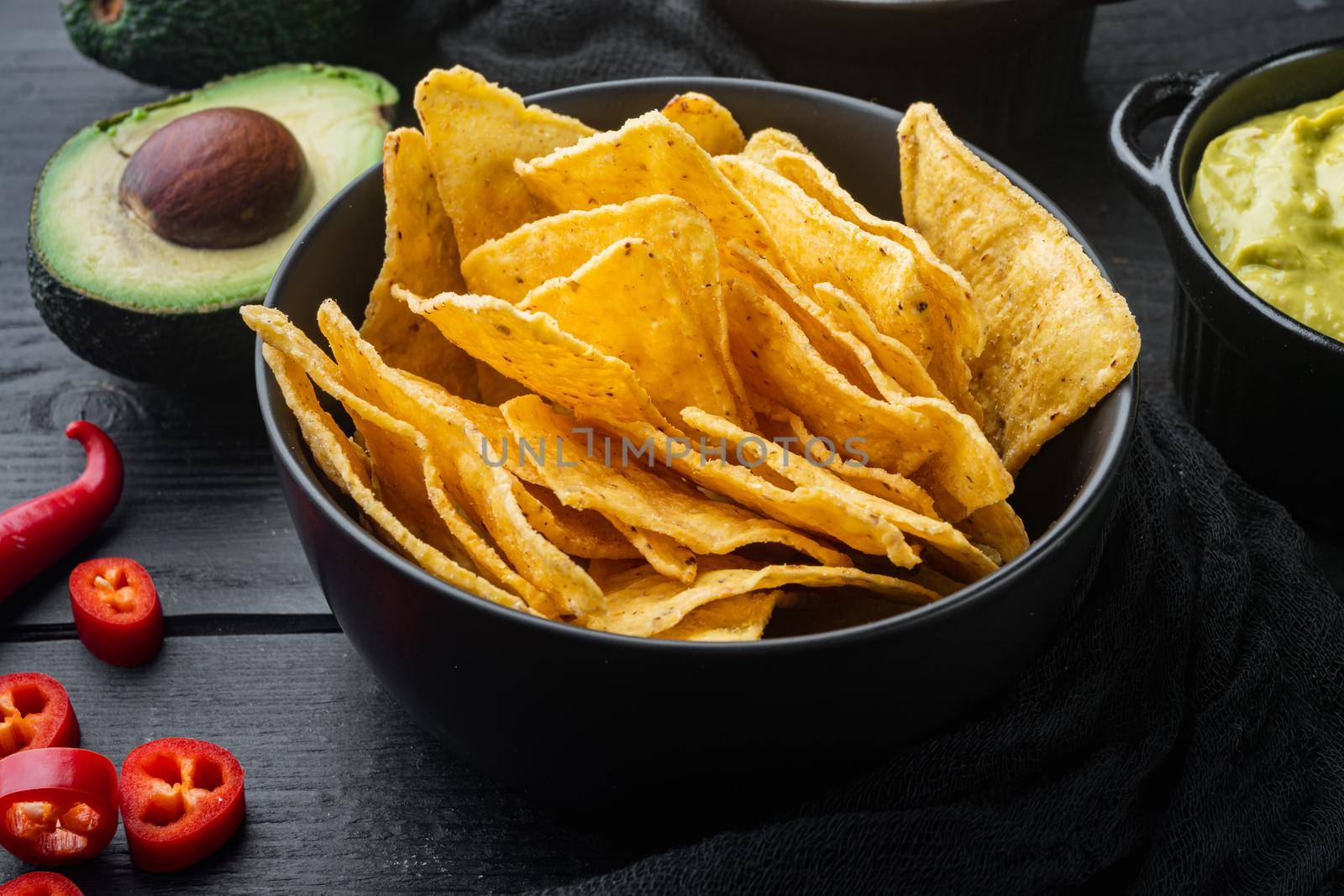 Mexican nachos chips with dip sauce, on black wooden background