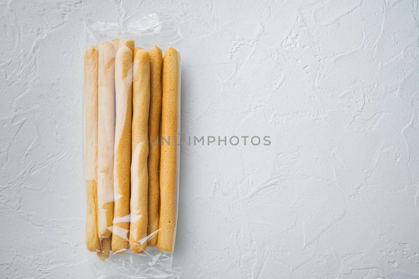 Breadsticks, with olive oil, on white background, top view with copy space for text
