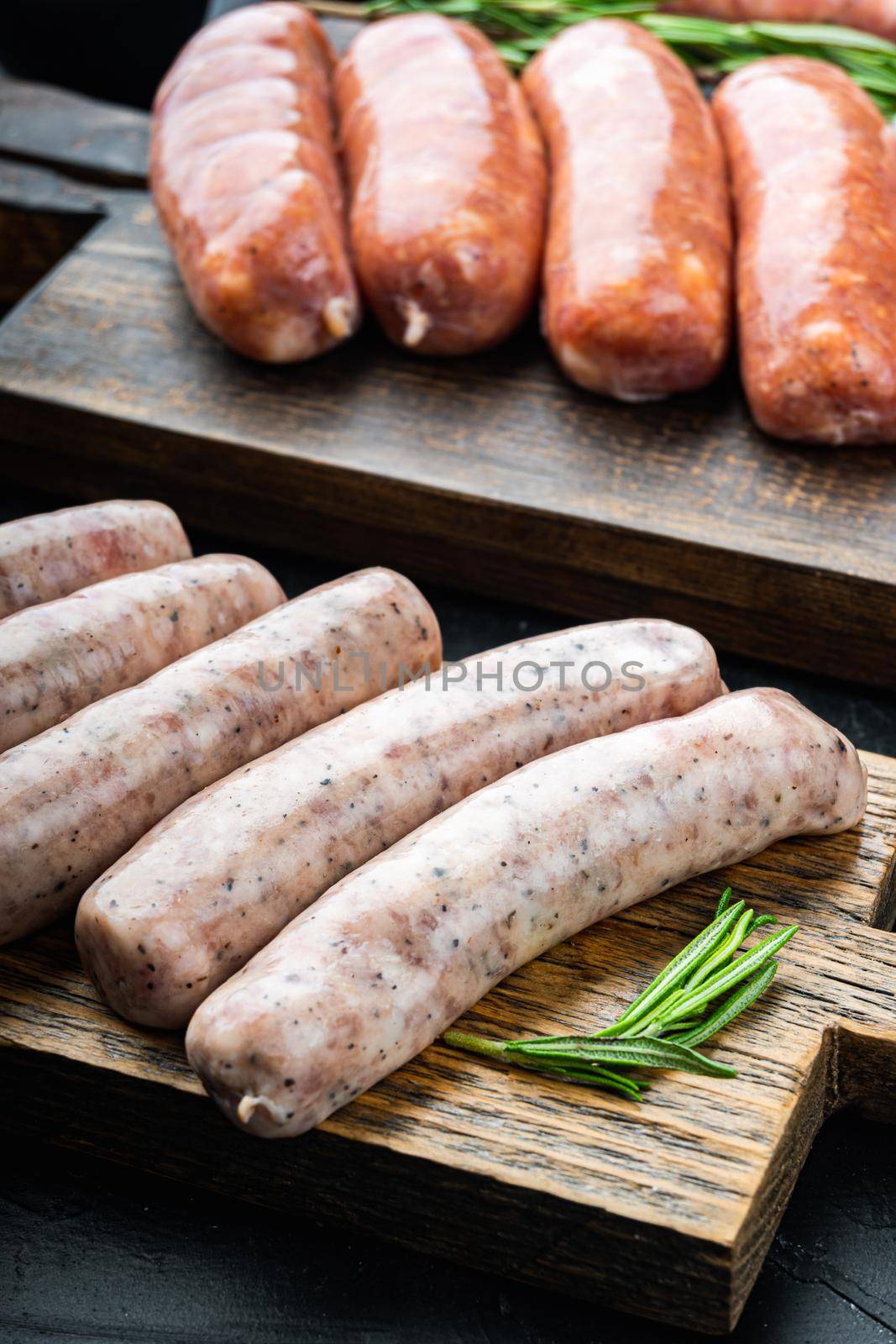 Chicken sausages, on black background.
