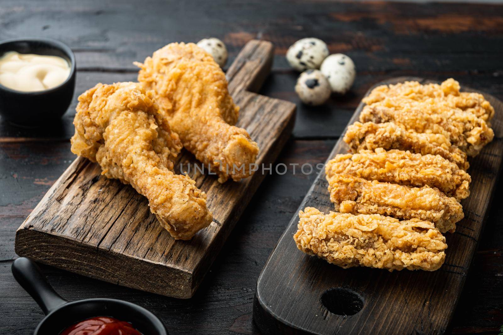 Southern fried chicken cuts on dark wooden background.