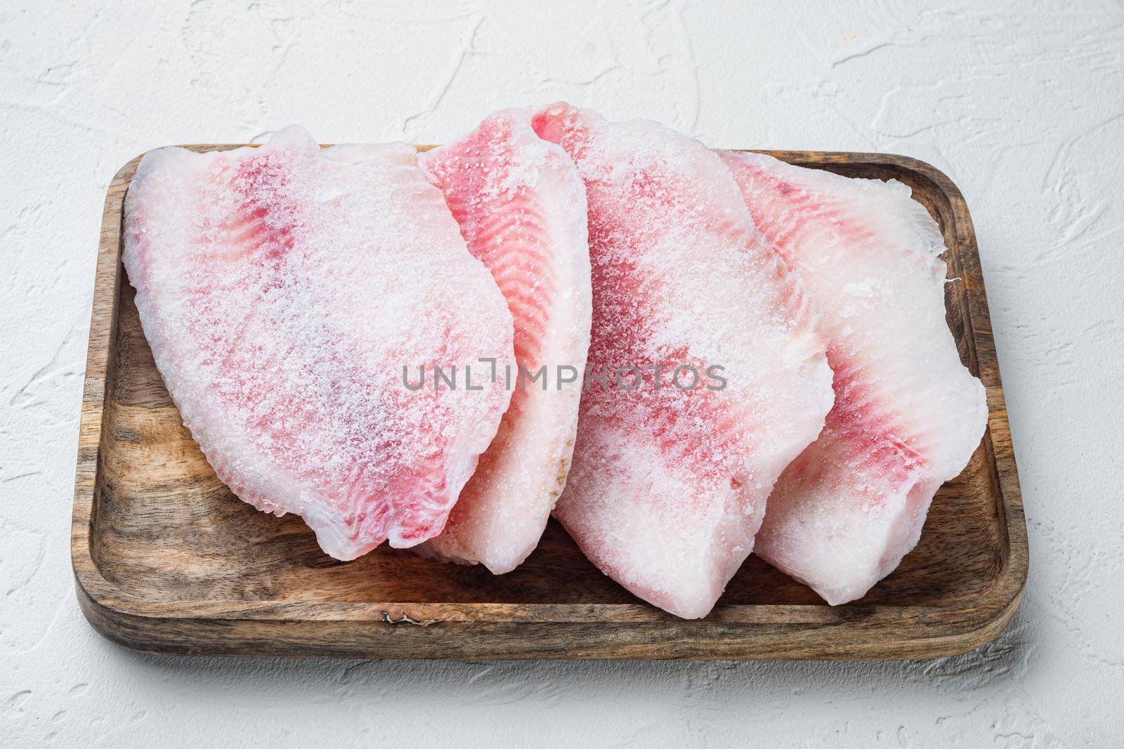 Frozen raw tilapia fish meat, on white background