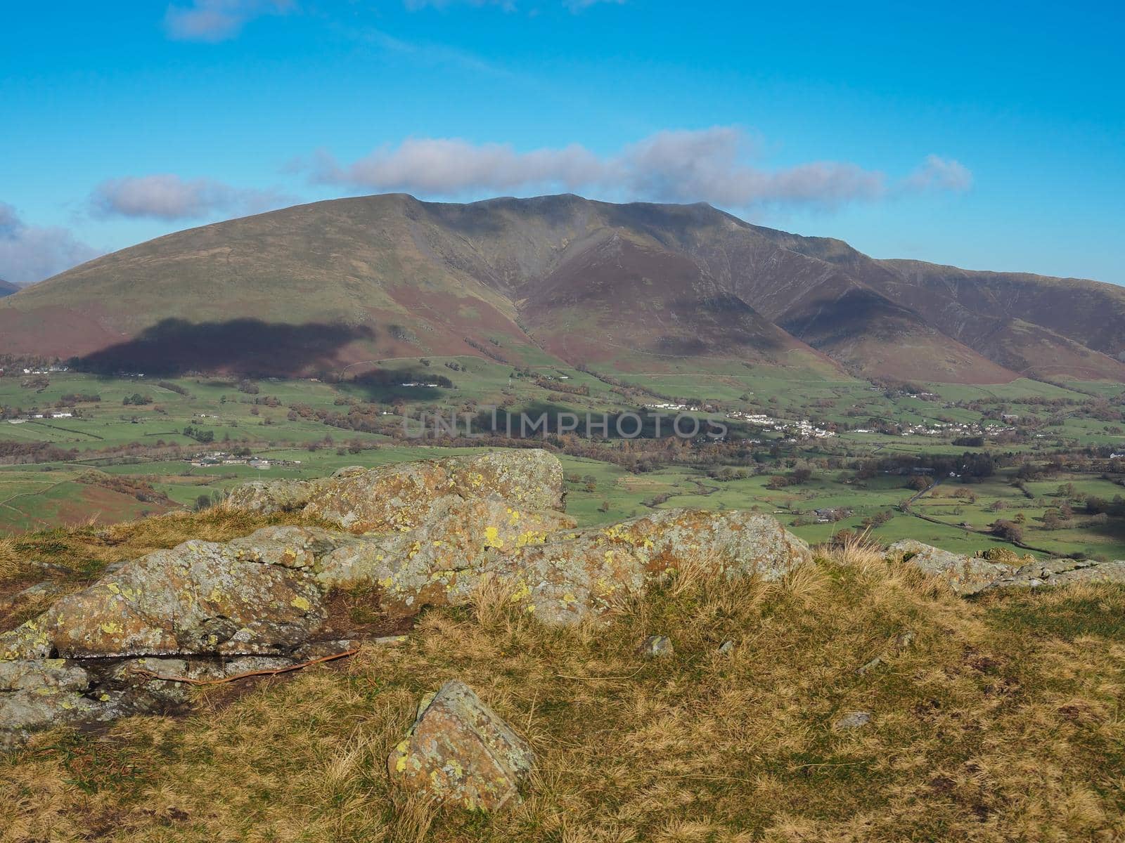 View from High Rigg looking at the peaks of Blencathra over St Johns in the Vale under a blue sky, Lake District, UK