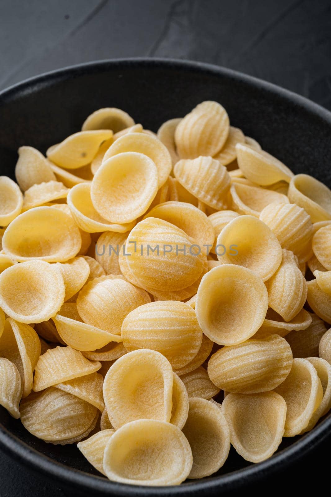 Durum wheat semolina pasta, on black background