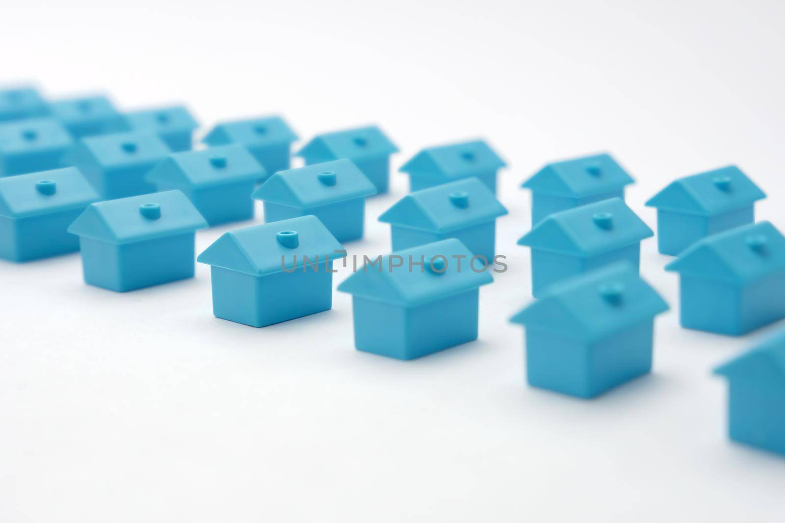 Real estate in cottage village. Home owner association. Rows toy houses. Miniature blue houses arranged in three rows. Miniature toy buildings. Many small houses. Miniature homes with property market by synel