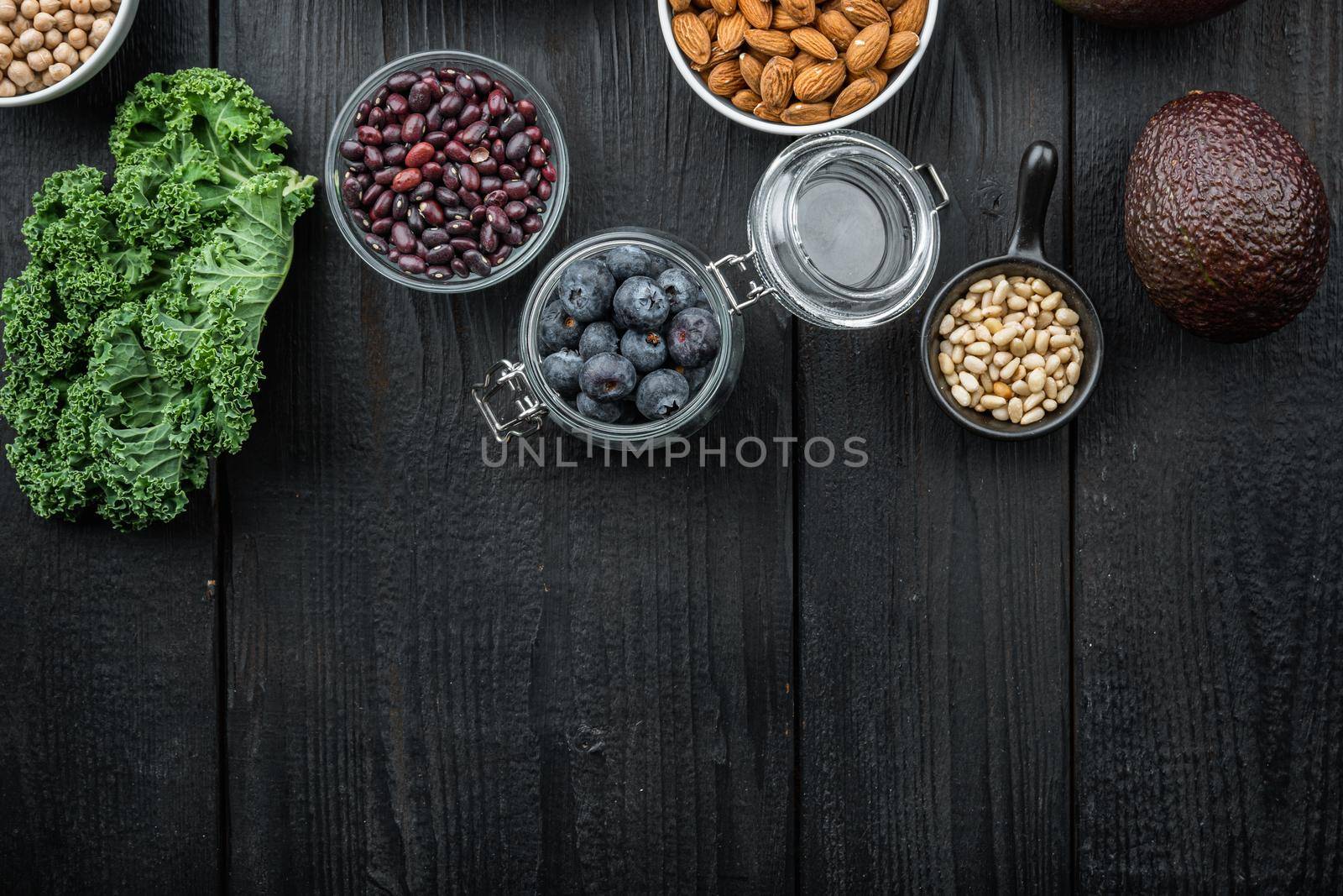 Balanced diet organic healthy food clean selection, flat lay with space for text, on black wooden background.
