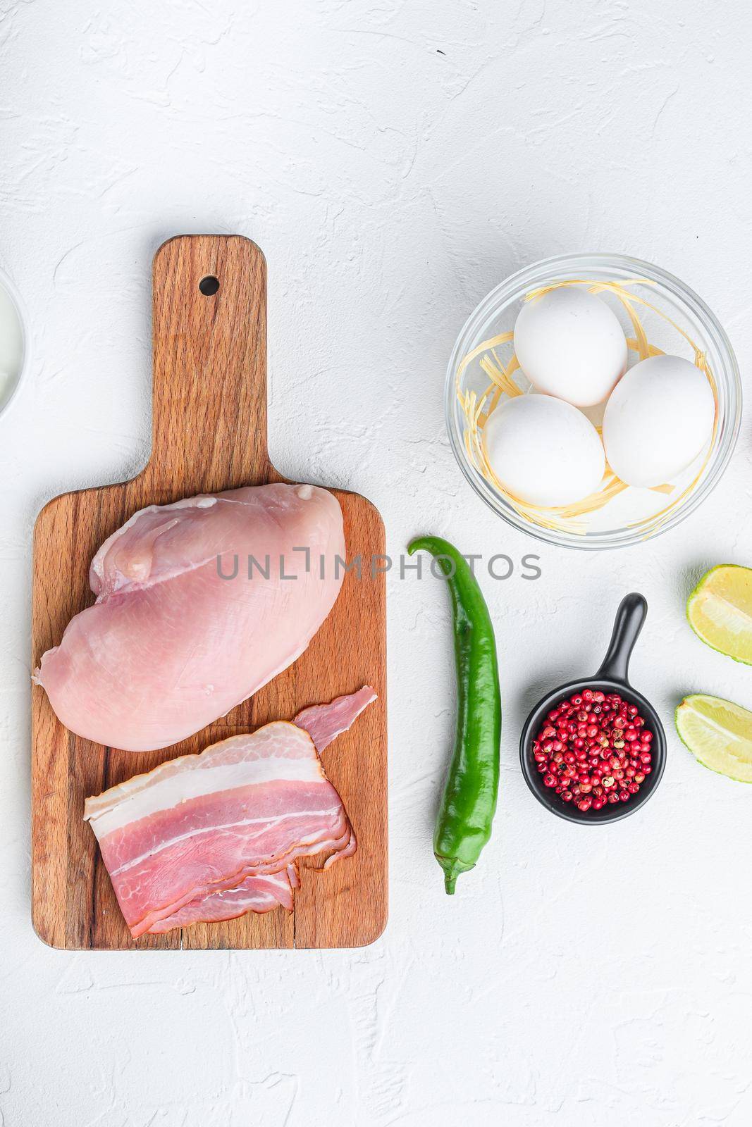 Chicken tacos organic raw ingredients , tomatoes, corn, egg, pepper,lime chicken meat and tortillas over white textured background top view.