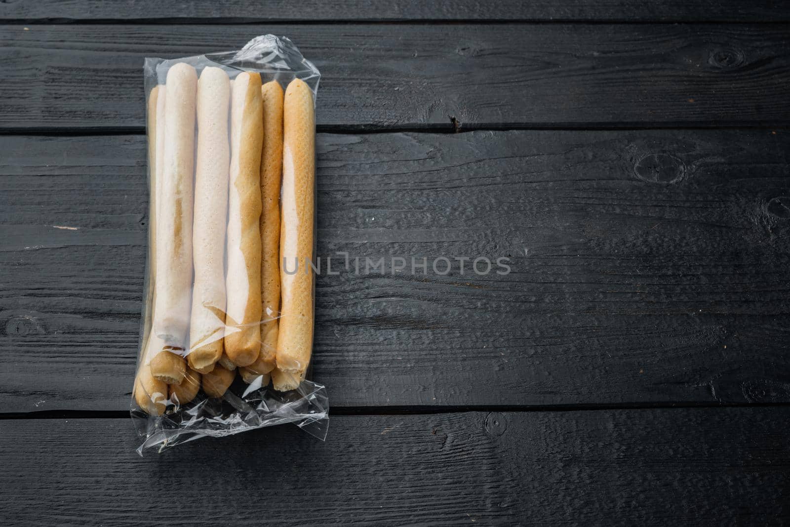 Grissini, with olive oil, on black wooden background with copy space for text