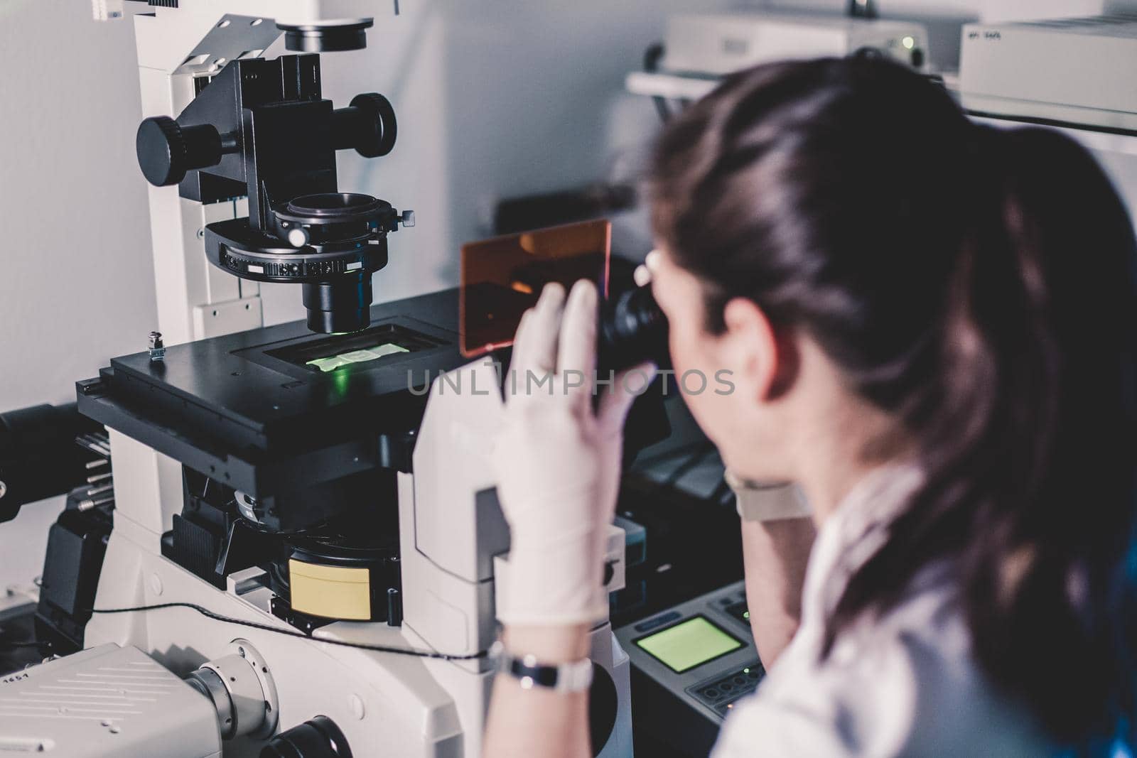 Life science female researcher microscoping in scientific genetic laboratory. Healthcare and biotechnology.